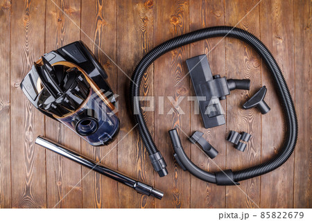 cheap cyclone type bagless vacuum cleaner with spare parts on wooden background in high angle directly above view cheap cyclone type bagless vacuum cleaner with spare parts on wooden background in high angle directly above view 85822679