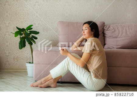 Attractive young woman enjoying coffee and relaxing at home. 85822710