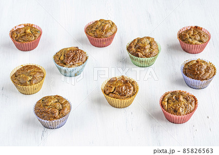 side view homemade muffins in colorful molds on white table side view homemade muffins in colorful molds on white table 85826563