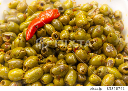 Green olive salad background with a chilli on top Green olive salad background with a chilli on top 85826741
