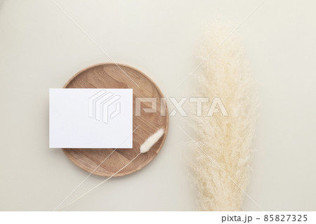 Blank paper cards, Mockup with pampas grass on a wooden plate, beige background, Minimal beige workplace composition, flat lay, mockup Blank paper cards, Mockup with pampas grass on a wooden plate, beige background, Minimal beige workplace composition, flat lay, mockup 85827325