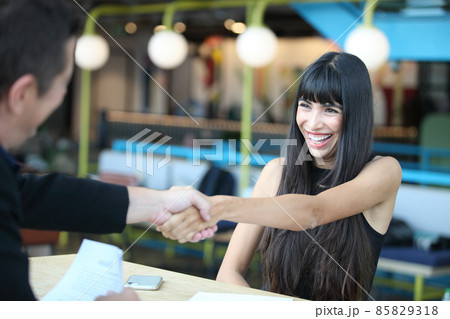 Young woman signing contracts and handshake with a manager,Businesswoman and businessman HR manager interviewing woman. Young woman signing contracts and handshake with a manager,Businesswoman and businessman HR manager interviewing woman. 85829318
