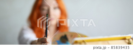 A woman holds a brush with a palette for paints A woman holds a brush with a palette for paints 85839435