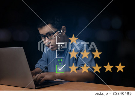 Young man browsing at his computer laptop with virtual screen on the smiley face icon on the digital touch screen. Young man browsing at his computer laptop with virtual screen on the smiley face icon on the digital touch screen. 85840499