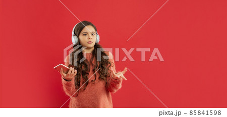 unpleased kid in sweater listen music in earphones hold phone, copy space, technology 85841598