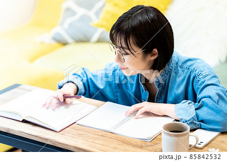 リビングで勉強する眼鏡の若い女性 85842532