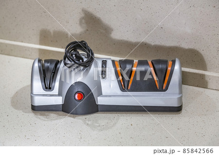 Modern electric knife sharpener in the home kitchen Modern electric knife sharpener in the home kitchen 85842566