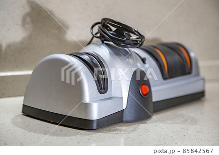Modern electric knife sharpener in the home kitchen Modern electric knife sharpener in the home kitchen 85842567