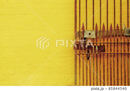 Rusty antique lock gate and bright yellow wall 85844540
