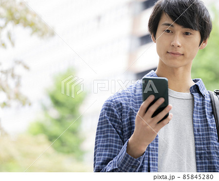 スマートフォンの画面を見る若い男性 85845280