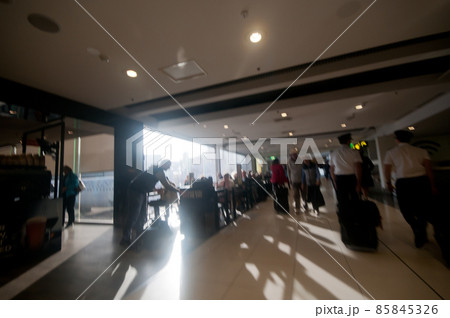 Blurry scene of morning chaotic airport with many passengers and captains Blurry scene of morning chaotic airport with many passengers and captains 85845326