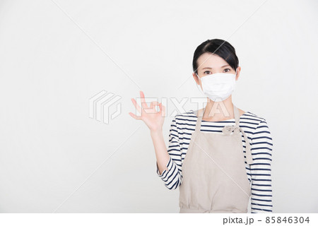 OKサインを出すマスクをしたエプロンの女性 85846304