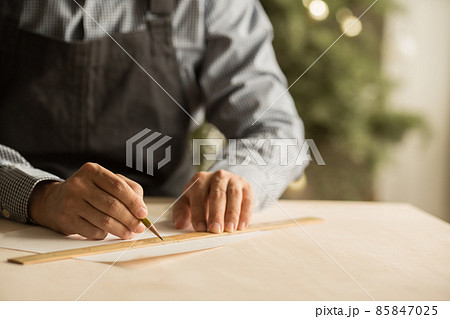工房で設計デザインする男性職人の手元 85847025