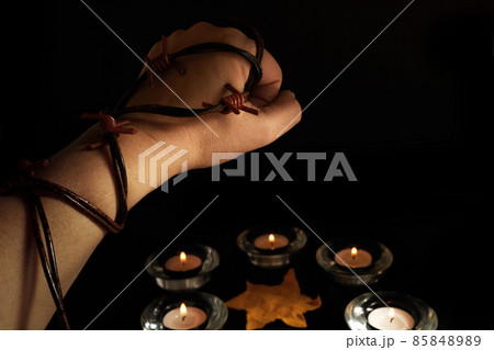 Holocaust Remembrance Day. Hand and barbed wire on black background. 85848989