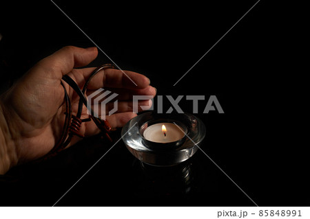Holocaust Remembrance Day. Hand and barbed wire on black background. 85848991