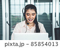 Businesswoman wearing headset working actively in office 85854013