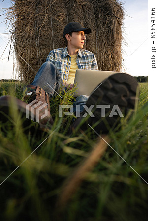 Farmer with laptop on the field Farmer with laptop on the field 85854166