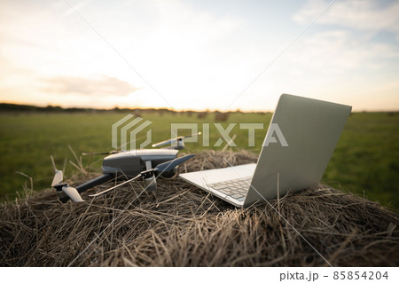 Laptop and drone on the field Laptop and drone on the field 85854204