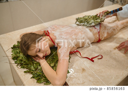 Woman in bath getting steaming broom massage 85856163