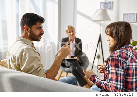 Unhappy couple arguing disagreement at psychologists office 85856213