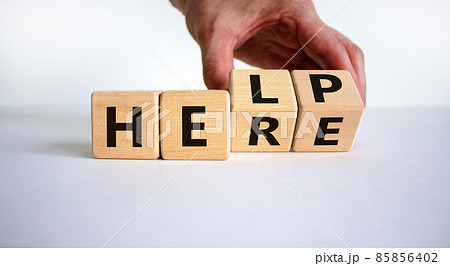 Help is here symbol. Businessman turns cubes and changes the word help to here. Beautiful white background, copy space. Business, motivational and help is here concept. 85856402