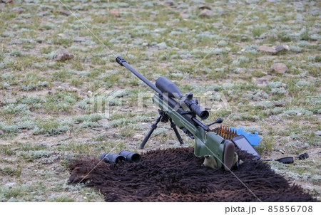 High-precision hunting rifle with an optical sight, cartridges and binoculars on the sighting. 85856708