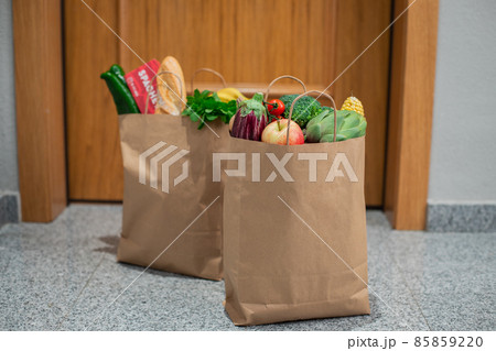 Food shopping bags stand at the door of the house or apartment. Vegetables and fruits delivery during quarantine and self-isolation. 85859220