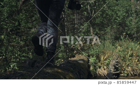 Traveler photographing scenic view in forest river. Wood bridge fallen tree. One caucasian woman shooting nice magic look. Girl take photo on camera. Traveler photographing scenic view in forest river. Wood bridge fallen tree. One caucasian woman shooting nice magic look. Girl take photo on camera. 85859447