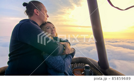 Adventure love couple on hot air balloon watermelon. Man and woman kiss hug love each other. Burner directing flame into envelope. Happy people. 85859689