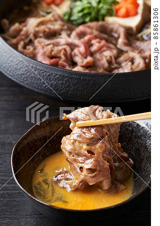 すき焼き肉を生卵に漬けて食す 85861306