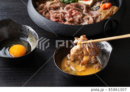 すき焼き肉を生卵に漬けて食す 85861307