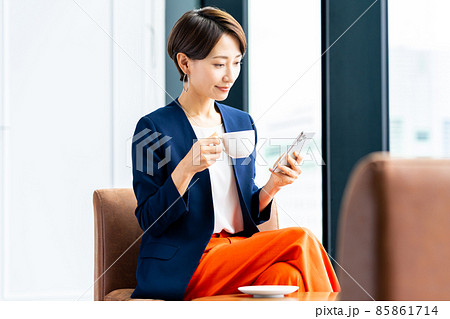 カフェでスマホを見るミドルの女性 85861714