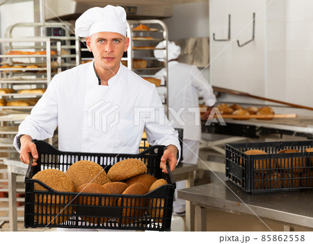 man in chefs uniform with bread in tray in bakery man in chefs uniform with bread in tray in bakery 85862558