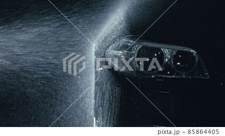 Car headlight wash. Washing modern vehicle body by high pressure jet wash hose water. Auto glass headlamp, angel eyes in drops. Car headlight wash. Washing modern vehicle body by high pressure jet wash hose water. Auto glass headlamp, angel eyes in drops. 85864405