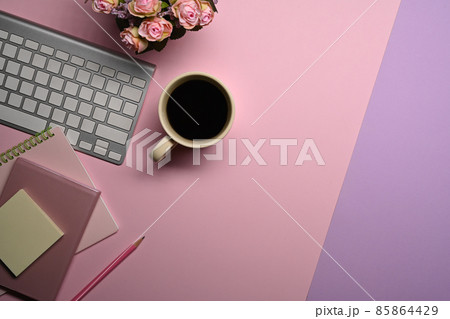 Top view coffee cup, notebook and wireless keyboard on feminine workspace. 85864429