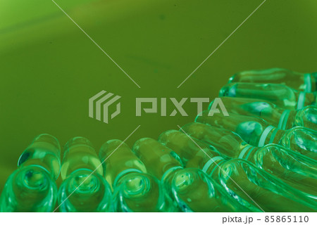 Glass medical ampoule vial for injection. Medicine is liquid sodium chloride with of aqueous solution in ampulla. Close up. Bottles ampule multicolor. 85865110