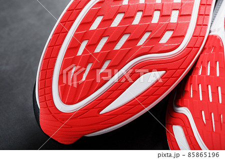 Running shoes with red soles on a black background. Running shoes with red soles on a black background. 85865196