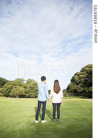 若い日本人カップルの後ろ姿、夏の朝、公園の芝生 若い日本人カップルの後ろ姿、夏の朝、公園の芝生 85869765