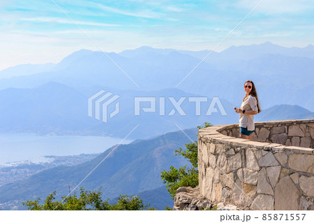 Young tourist woman enjoying view of Kotor bay in Montenegro in mountains Young tourist woman enjoying view of Kotor bay in Montenegro in mountains 85871557