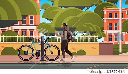 female cyclist taking break during bike ride woman in helmet with takeaway coffee cup standing near bicycle 85872414