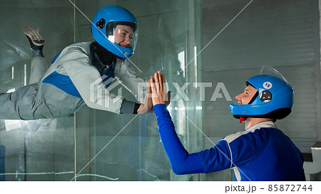 A man trains a woman as an astronaut. Classes on flying in a wind tunnel. 85872744