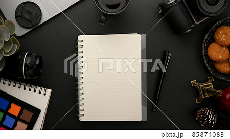 A notebook, a lecture book or a planner book on modern black workspace. 85874083
