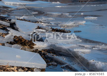 凍った湖と雪景色に射す陽射し 85874565