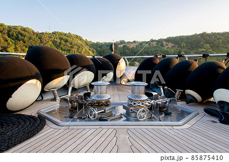 Anchor lowering and raising mechanism, Anchor Buoys and rigging on the foredeck of a luxurious yacht - selective focus Anchor lowering and raising mechanism, Anchor Buoys and rigging on the foredeck of a luxurious yacht - selective focus 85875410