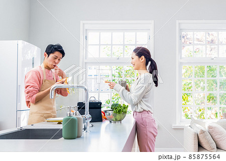 料理をする旦那と見守る主婦　指を切る 85875564