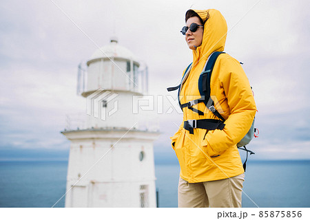 Portrait of a female traveler on the background of the sea. The concept of adventure, travel and hiking. A female tourist enjoys a beautiful landscape during a hike. Portrait of a tourist by the sea 85875856