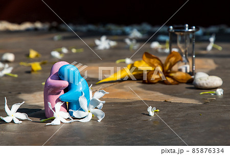 Blue and pink ceramic couple dolls hug with each other on stone background. Blue and pink ceramic couple dolls hug with each other on stone background. 85876334