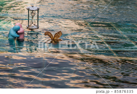 Blue and pink ceramic couple dolls hug with each other on pool water. Blue and pink ceramic couple dolls hug with each other on pool water. 85876335