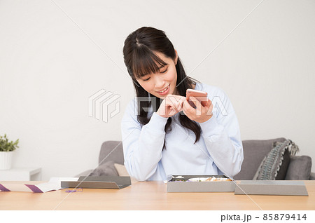 お弁当をスマホで撮影する女性 85879414