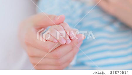 mom holds baby hand 85879614